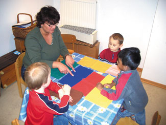 Manuela Cotterrell mit 3 Kindern am Tisch - Farben lernen